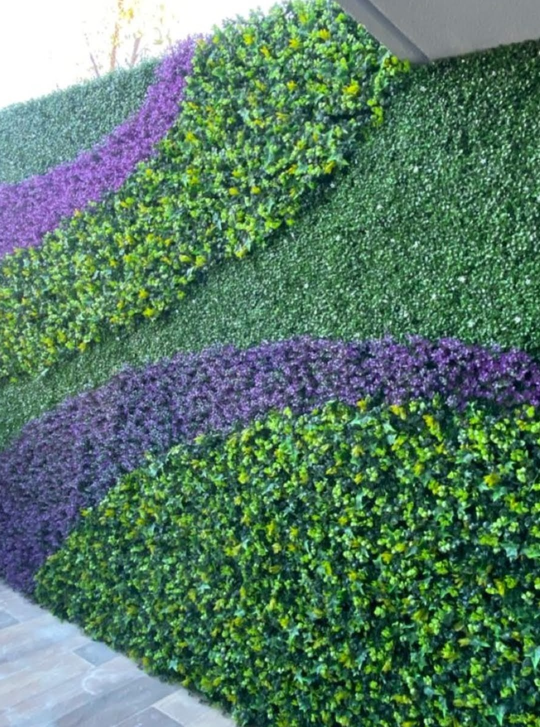 Muro decorativo con follaje verde y detalles morados