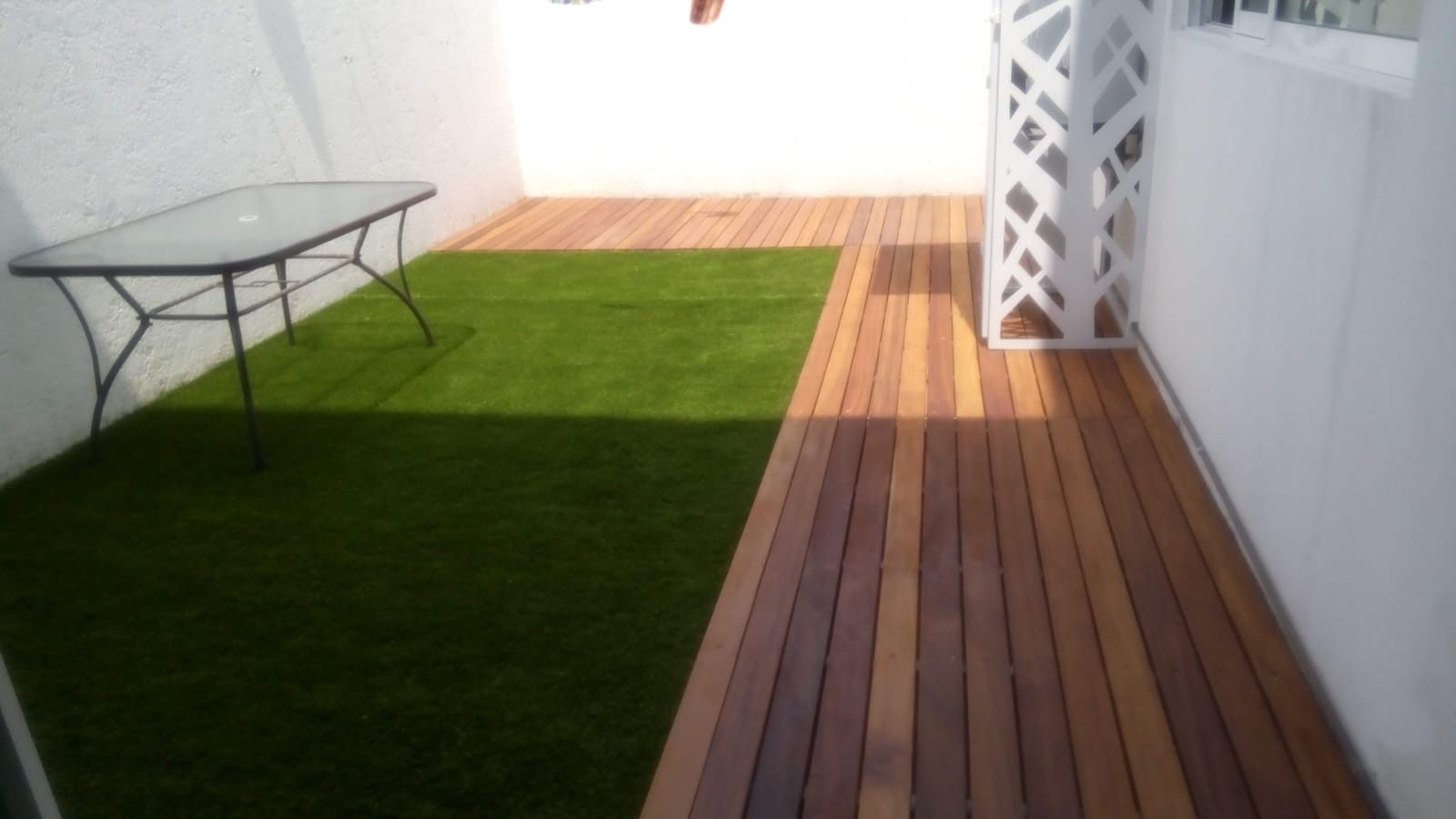 Área con pasto y acabado de madera