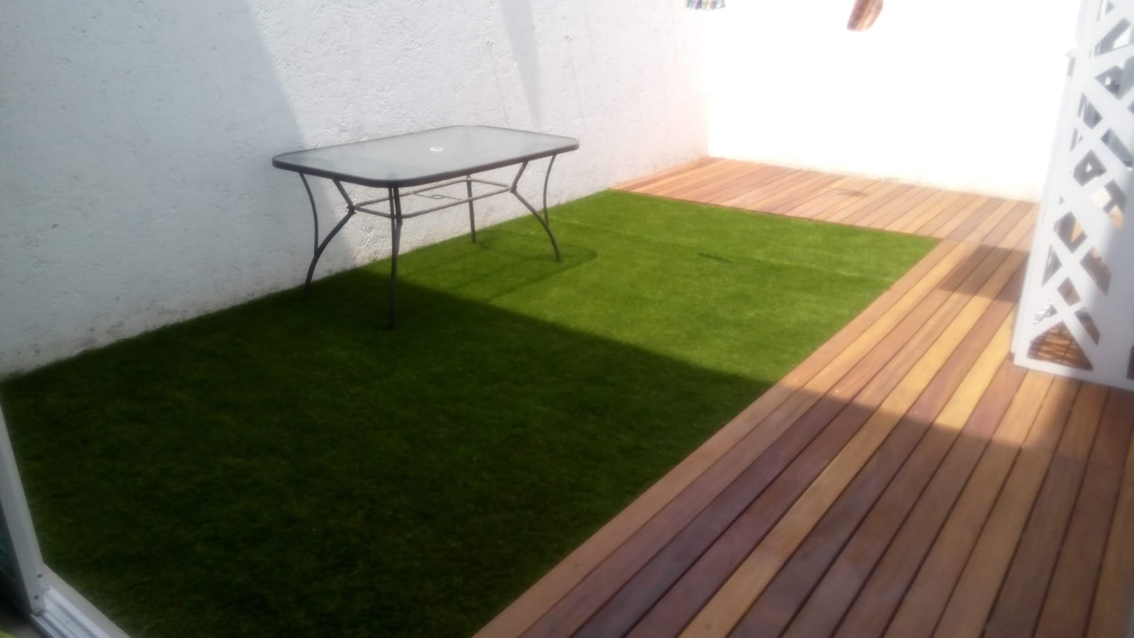 Vista de patio con pasto y acabado de madera